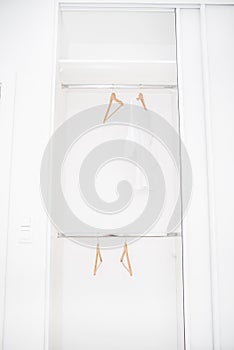 Female clothes and empty hangers on clothing rack.Sale in the store. Emptiness.Modern wardrobe with one white T-shirt and empty