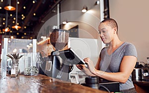 Female Coffee Shop Owner Working Behind Sales Desk