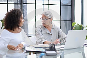 Female colleagues met in the office hall discussing work issues