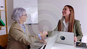 Female colleagues shacking hands in the office after business agreement.