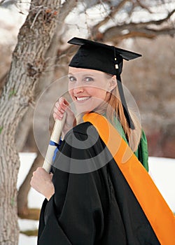 Female college graduate holding diploma outdoor