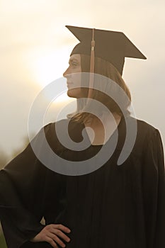 Female college graduate profile backlit by sun