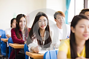 female college student sitting with classmates photo