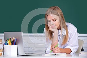 Female college student working on a laptop in classroom, preparing for an exam. Student education concept. Female