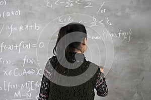 Female college students stand in front of the blackboard writing