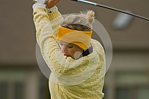 Female collegiate golfer swinging golf club photo