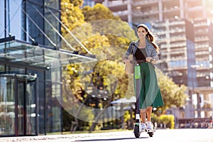 Female commuter riding electric push scooter