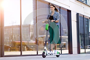 Female commuter riding electric push scooter photo