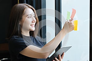 A female company employee using notepad and tablet to analyze company budgets.