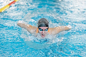 Female swimmer moving through the water performs a butterfly stroke