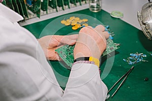 Female computer expert professional technician examining board computer in a laboratory in a factory.