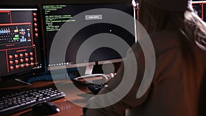 Female computer programmer coding, hacking in dark room.