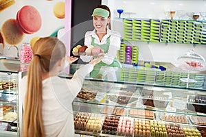 Female confectioner sales delicious macarons to girl