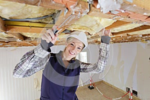 female constractor working and using screwdriver