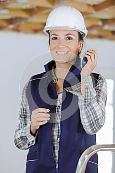 female construciton worker using walkie talkie