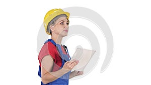 Female construction engineer looking at tablet and checking object on white background.