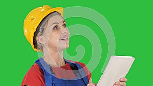 Female construction engineer with a tablet computer at a construction site on a Green Screen, Chroma Key.