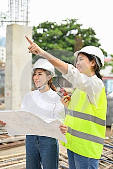 Female construction inspector explaining the plan to a female architect