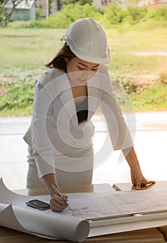 Female construction site engineer/Young engineers are checking the plan.