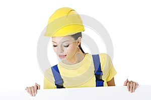 Female construction worker with blank board