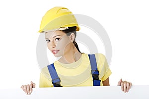 Female construction worker with blank board