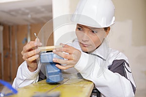 Female construction worker fixing sanding machine