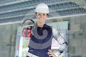 female construction worker giving earmuffs