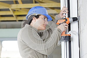 female construction worker holding screwdriver handtool and cordless screwdriver photo