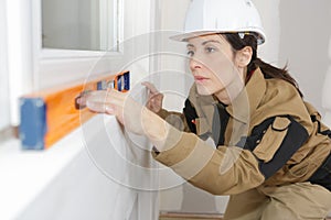 Female construction worker installing windows