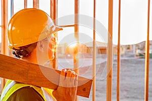 Female Construcion Worker Looking Out From New Home Framing