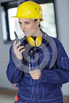 female construction worker relaying directions on walkie talkie