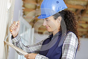 female construction worker removing wallpaper with scraper