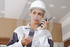 Female construction worker talking into walkie talkie