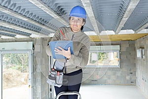 female construction worker with toolkit and ladder
