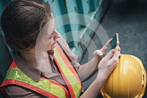 Female Construction Worker Using Mobile Phone While Resting in Workshop Warehouse, Close-Up of Logistics Woman Labor Used