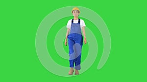 Female construction worker walking and looking to the sides on a Green Screen, Chroma Key.