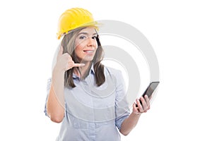 Female constructor holding phone showing calling gesture photo