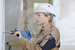 Female contractor holding driller