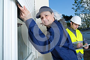 Female contractor installing window shutter