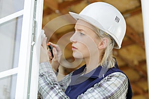 female contractor screwing handle onto window photo