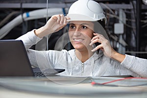 female contractor using laptop in roofspace