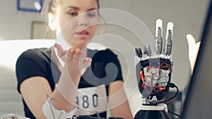 Female controls electronic prosthetic arm using bionics technology.