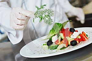 female cook chef decorating prepared salad food