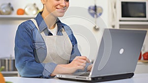 Female cook filling out application for participation in culinary show on laptop