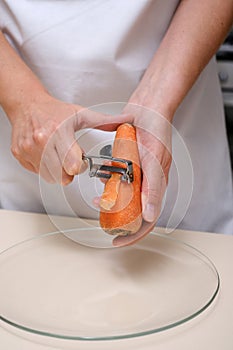 female cook peeling carrots hands close-up