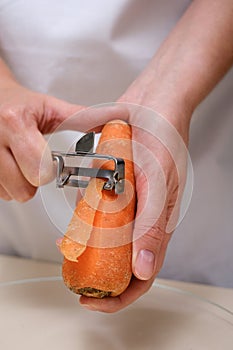 female cook peeling carrots hands close-up