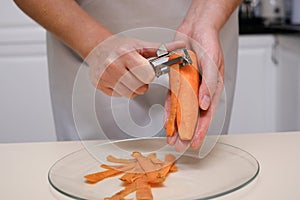 female cook peeling carrots hands close-up