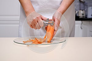 female cook peeling carrots hands close-up