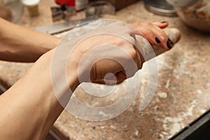 Female cook preparing the dough to make cookies in a kitchen