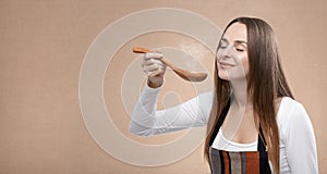 Female cook smells a steaming spoon